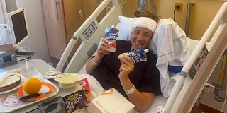Kiana Cormack glimlachend in een ziekenhuisbed, na haar hersenoperatie. Bron: eigen foto. 