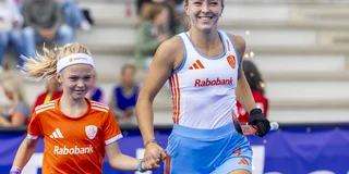 Renée van Laarhoven loopt het veld op als international, met aan haar hand een meisje met oranje tenue. 