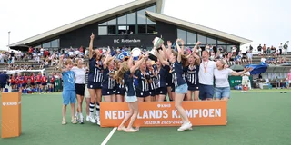 HDM MO-18 juicht na het winnen van de landstitel, met beker in de hand en medailles om hun nek. 
