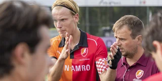 Joep de Mol spreekt tijdens een pauze zijn ploeg toe, met naast hem coach Jeroen Baart.
