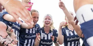 Blijdschap in de huddle van HDM na afloop van de finale, met een lachende en klappende Elin Mantel in het midden.